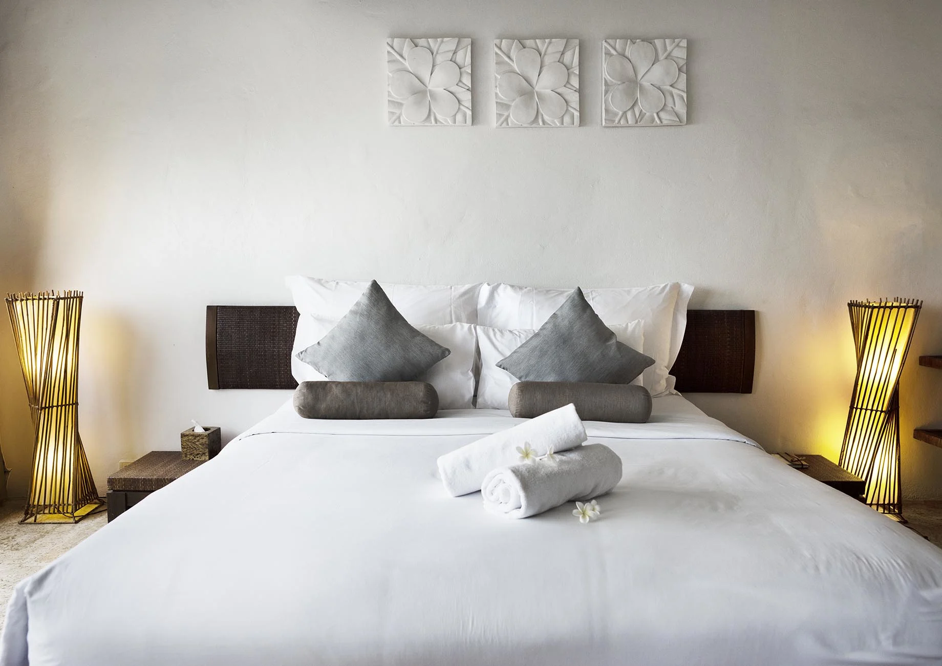Bed dressed in white cotton sateen bedding with scalloped embroidery